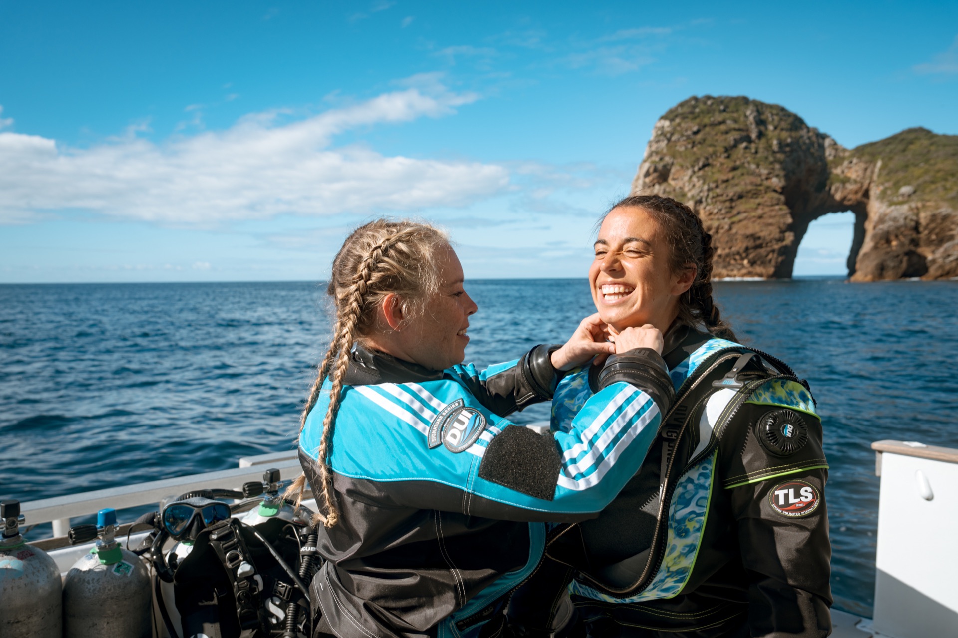 Divers preparing for a dive on a sunny boat deck