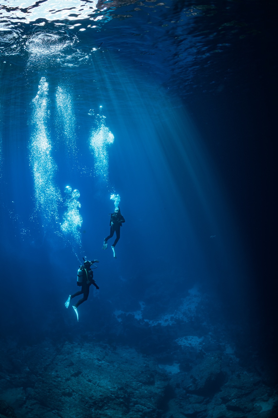 Sunbeams breaking into a cavern full of divers