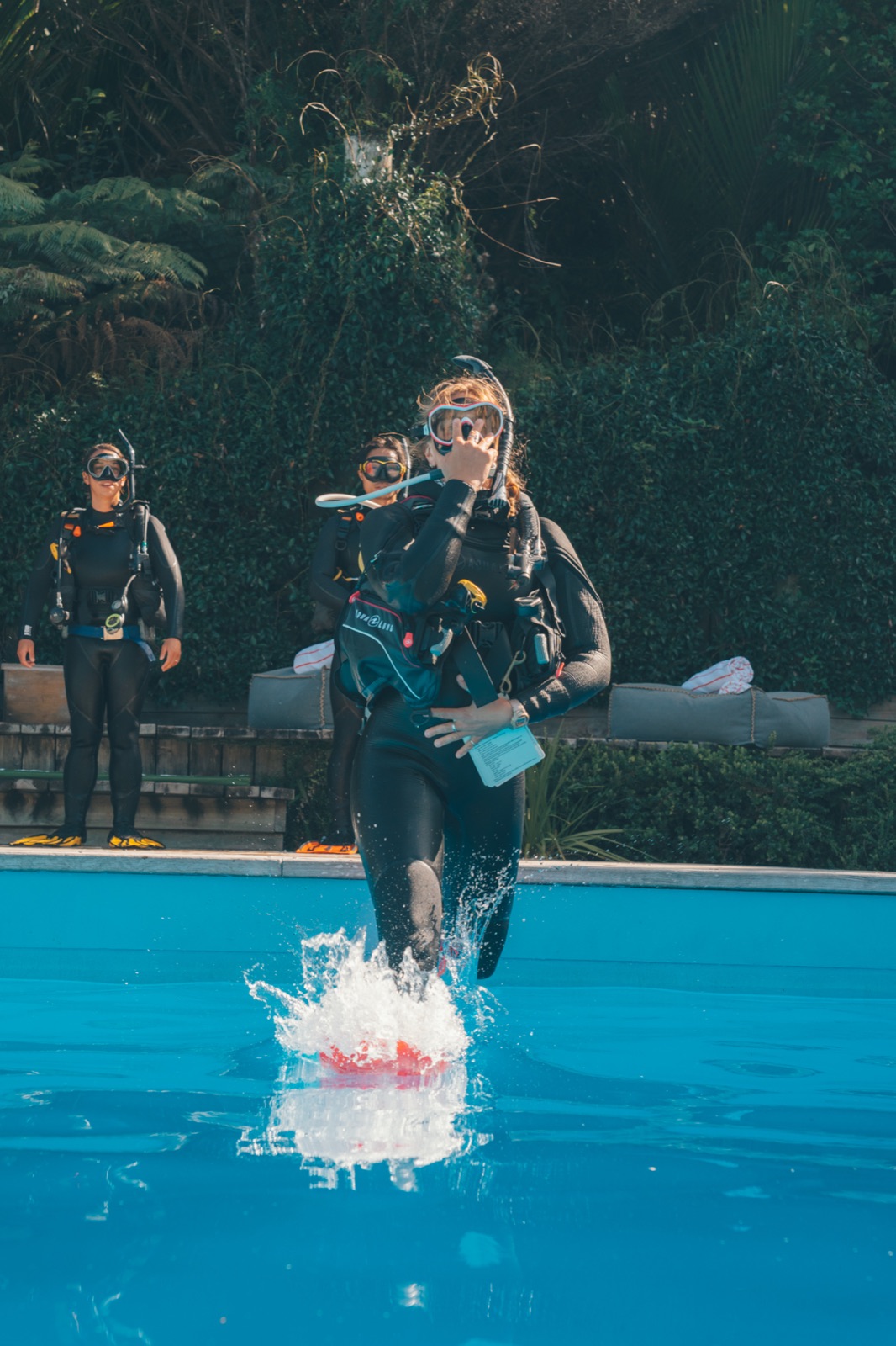 A student taking a giant stride into a training pool