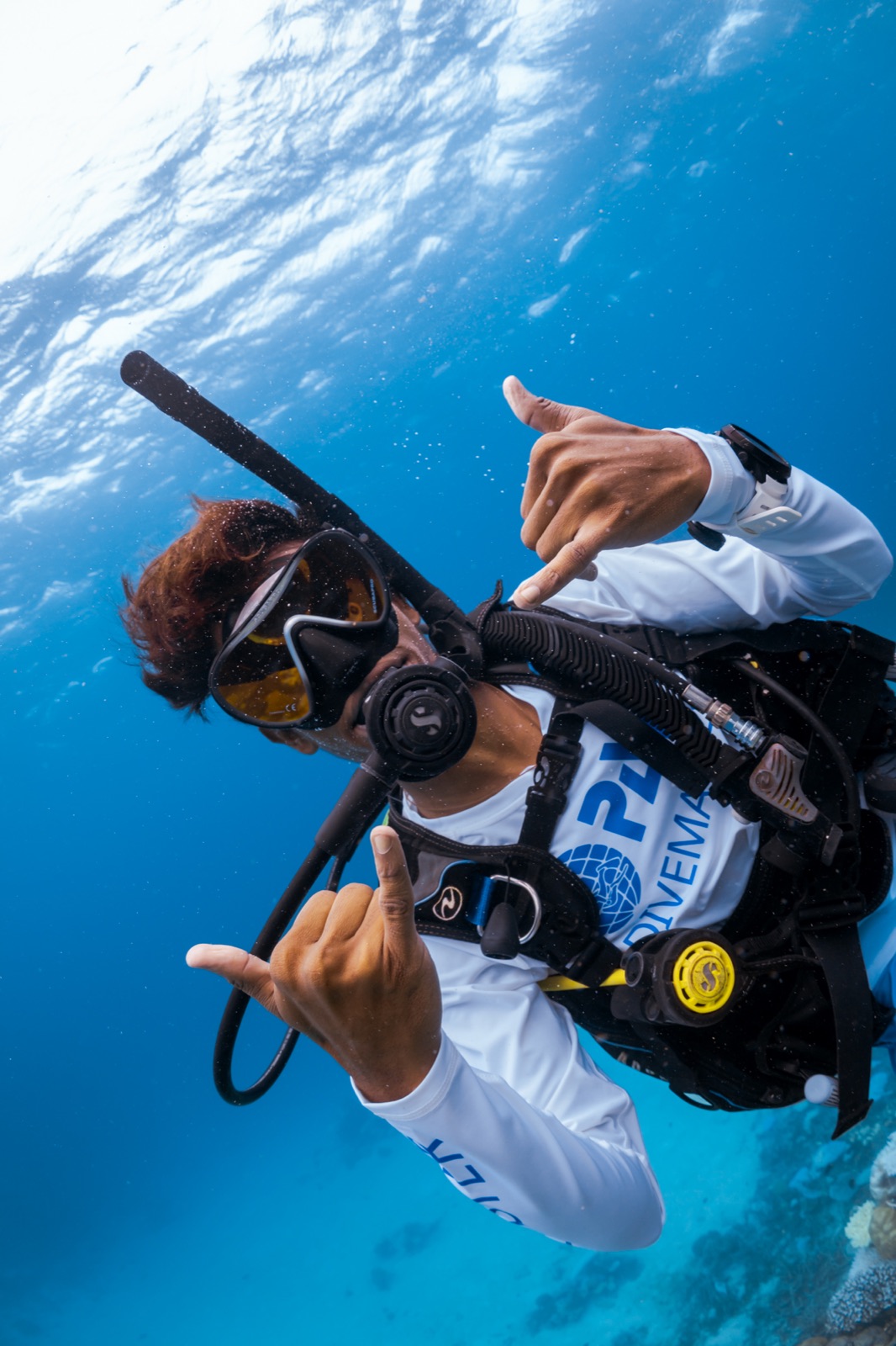 A PADI instructor guiding a student over a reef